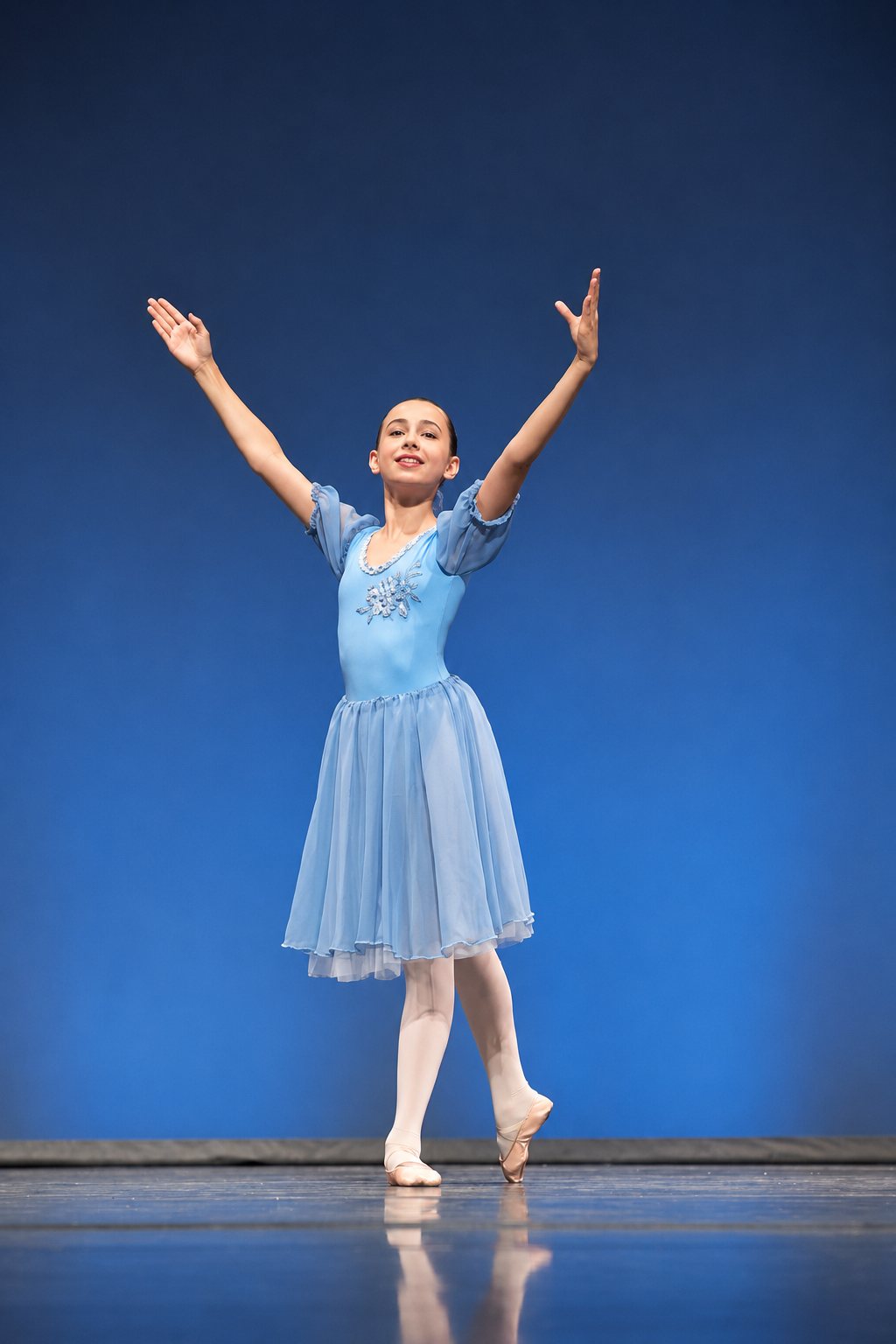 Danseuse en équilibre sur demi-pointe et port de bras